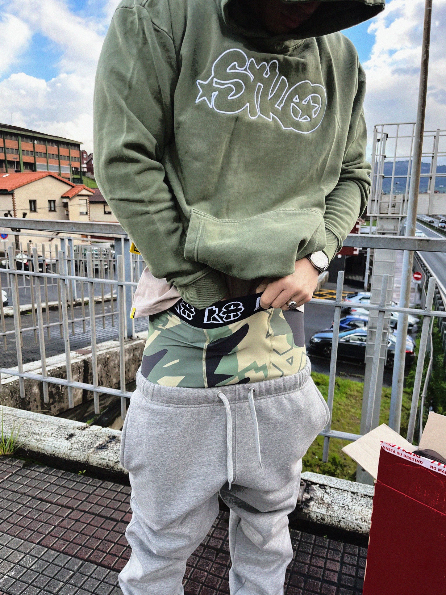 Urban guy wearing grey tracksuit and green astonishing hoodie