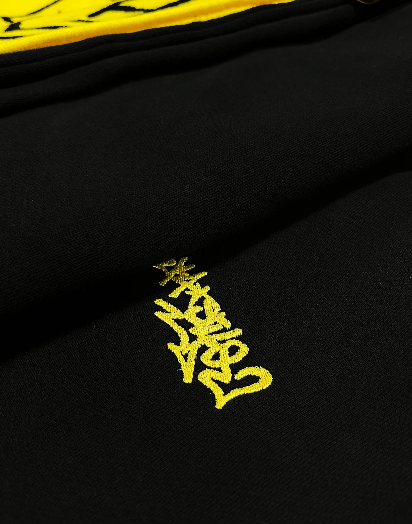 embroidered logo of a urban brand in a black hoodie